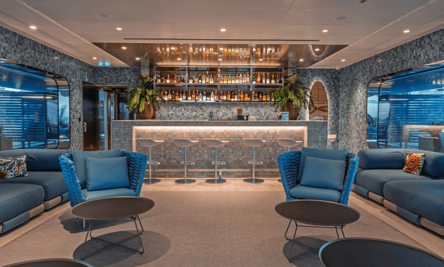 Two blue lounge chairs in a bar on a cruise ship