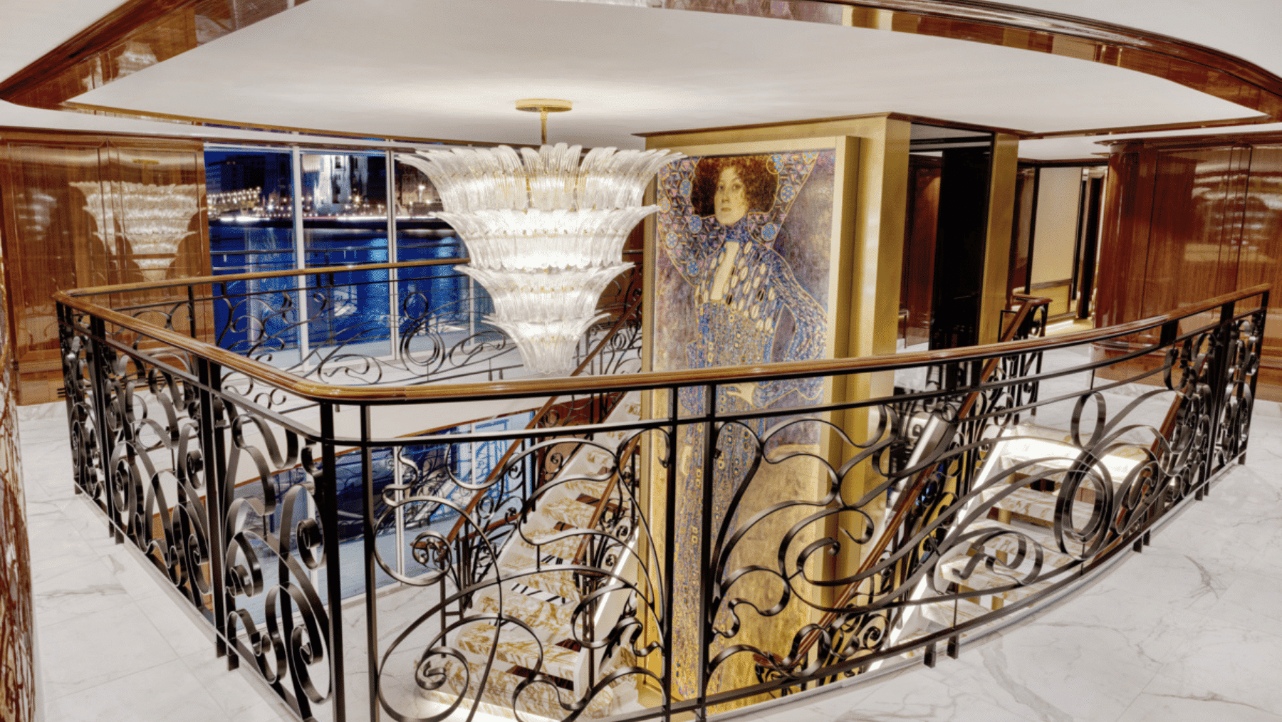 A large portrait hangs in the entry way of a ship alongside a chandelier