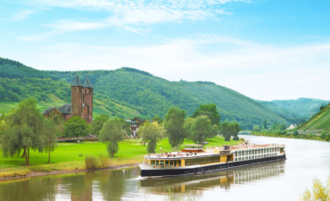 A river cruise boat on a river with a castle in the background