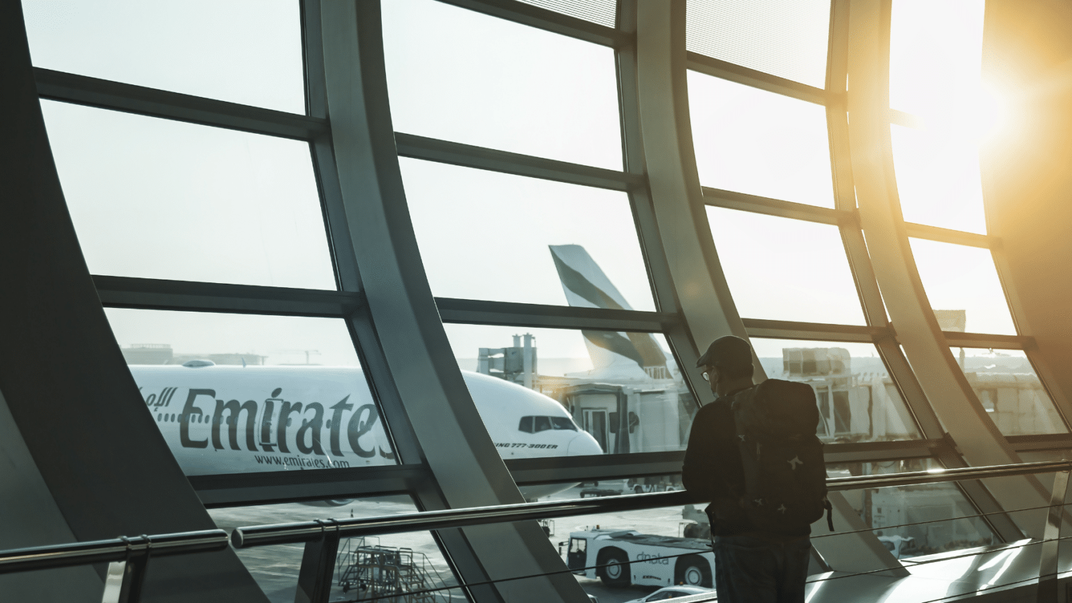 Stock image of a man inside a terminal looking outside to an airplane