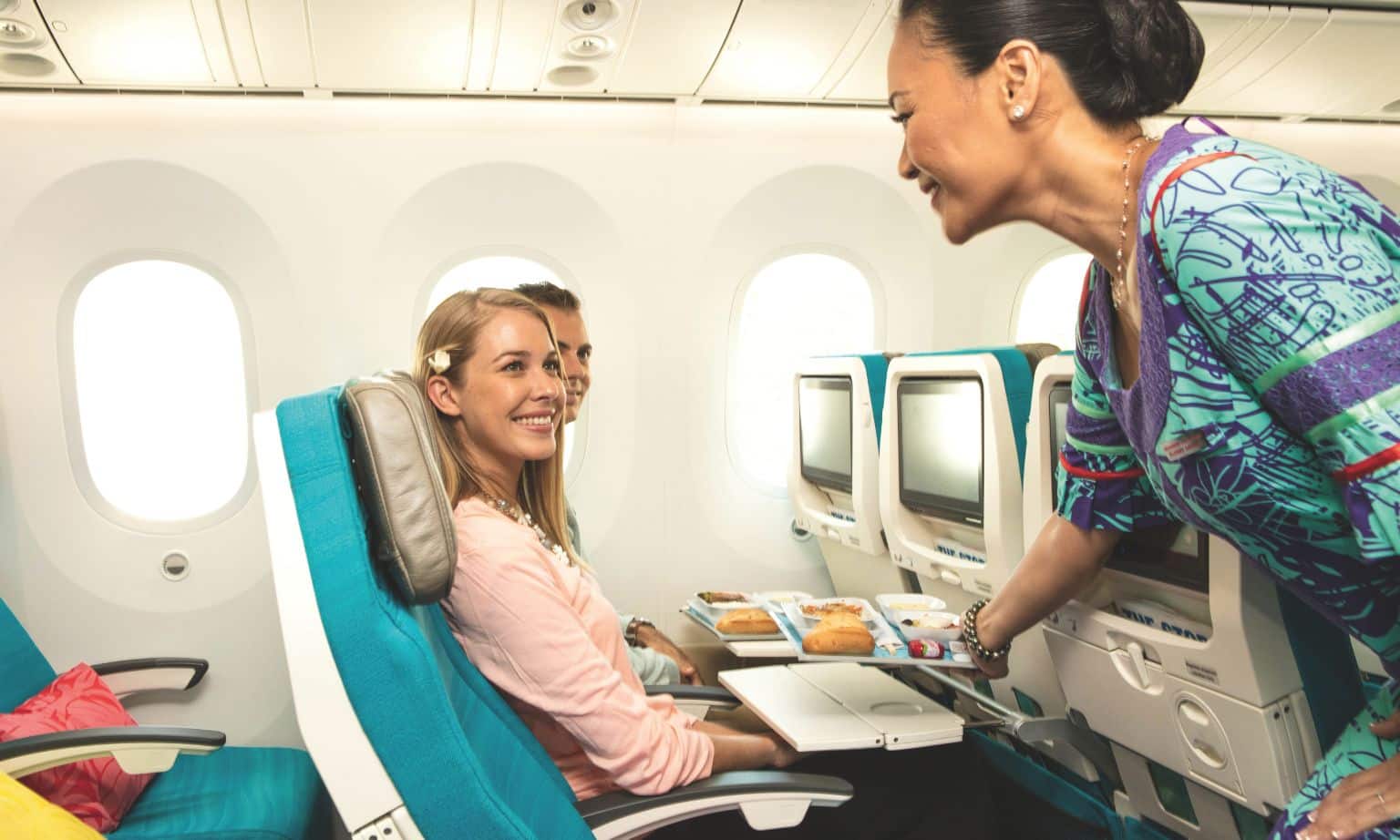 An Air Tahiti Nui stewardess serving lunch in economy